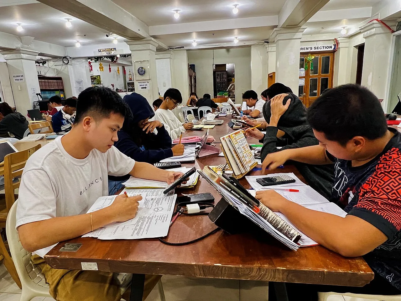 Students studying together at a table in a public library